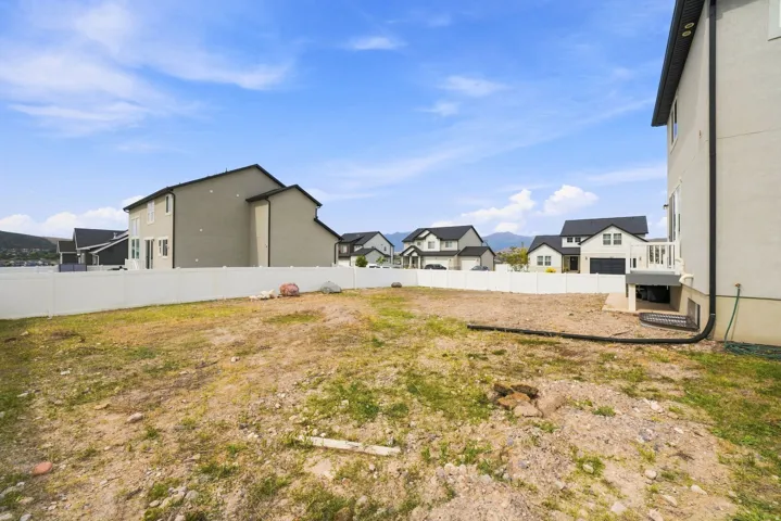 Expansive undeveloped lot with existing perimeter fencing and mountain backdrop