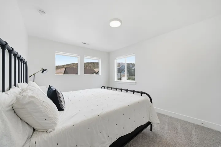 Neutral wall color with recessed lighting, multiple windows, and carpeted flooring