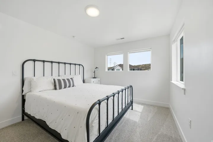 Light-filled room featuring multiple windows, recessed lighting, and soft gray carpeting
