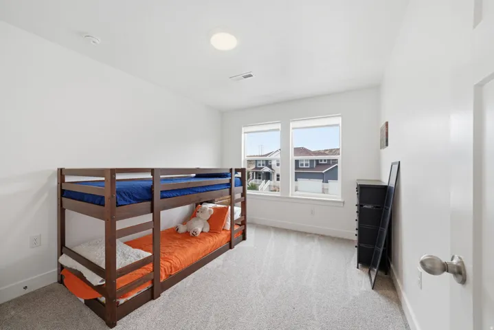 Neutral wall paint, recessed ceiling lighting, light-toned carpet flooring, and two windows with white trim
