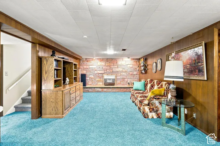 Wood paneling, a stone-faced fireplace with hearth, and built-in cabinetry create a distinct aesthetic