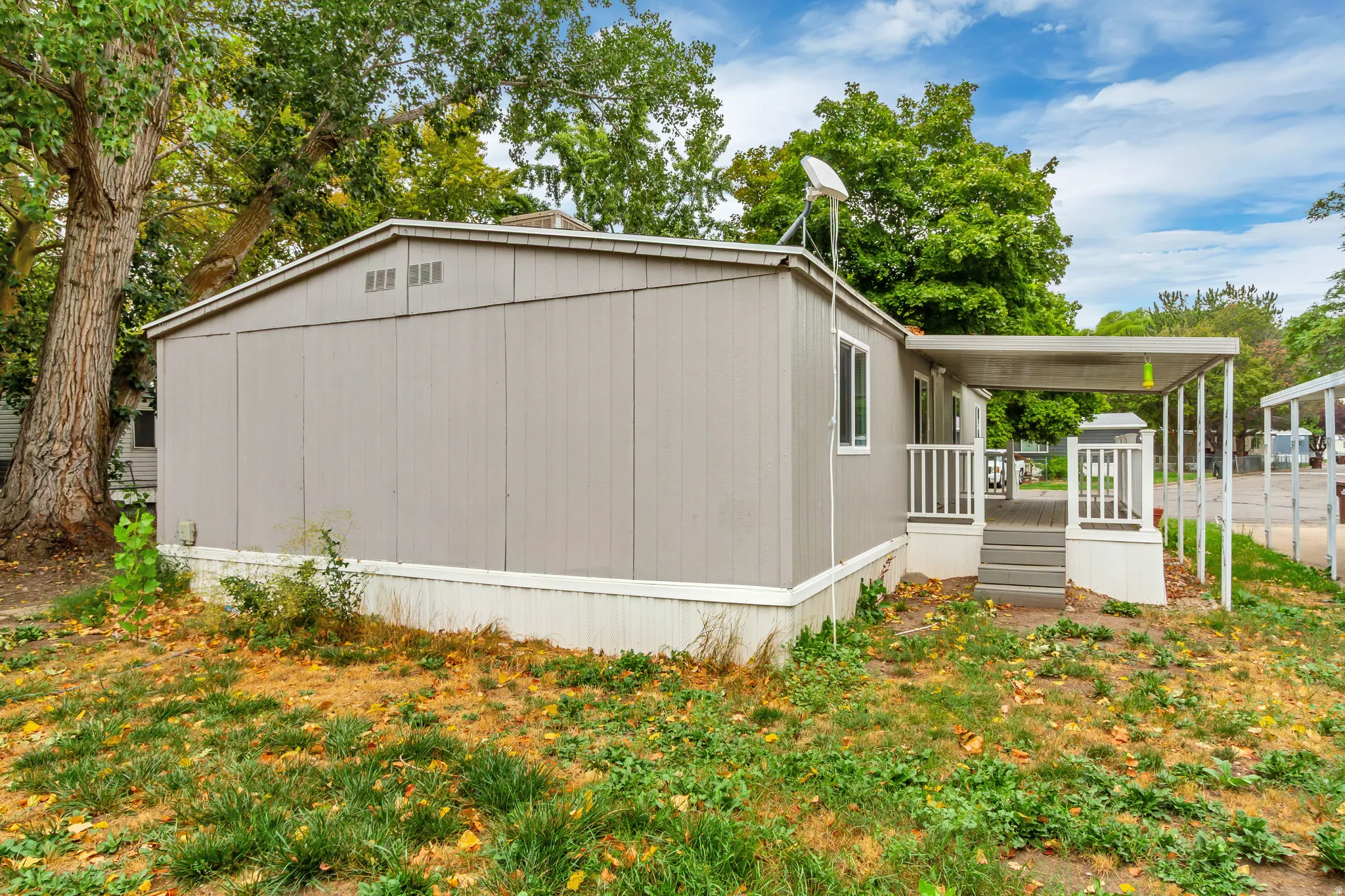 Light gray exterior with white trim, covered porch, and white porch railings