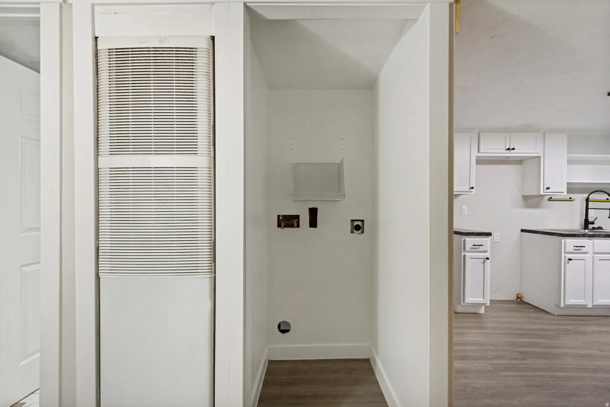Dedicated laundry area with utility hookups and wood-finish flooring
