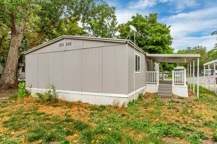 Light gray exterior with white trim, covered porch, and white porch railings