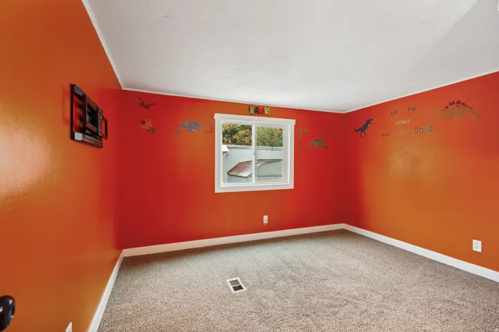 Textured carpet flooring, white trim, and a white framed window