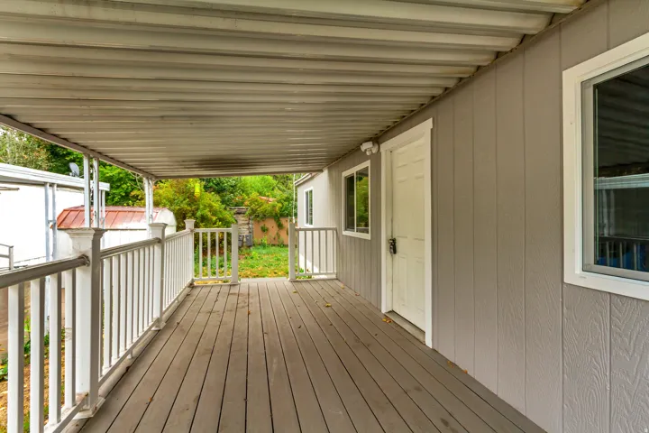 Covered porch with wood-finish decking and white railings