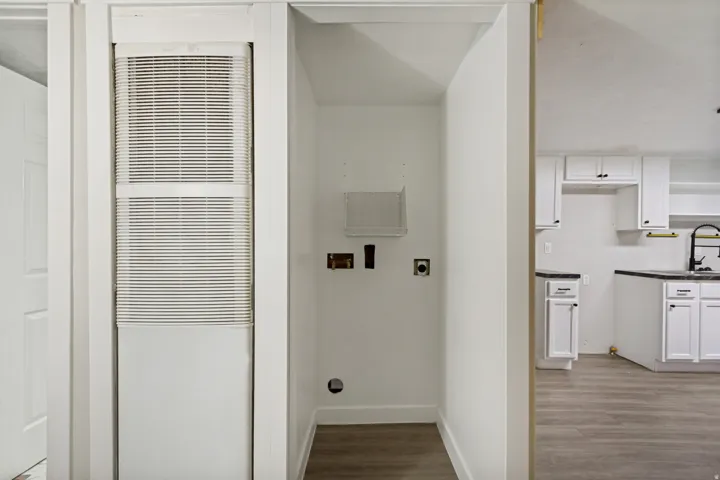 Dedicated laundry area with utility hookups and wood-finish flooring