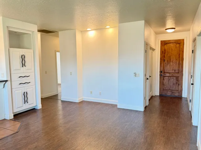 Wood-finish flooring, recessed lighting, and a solid wood entry door