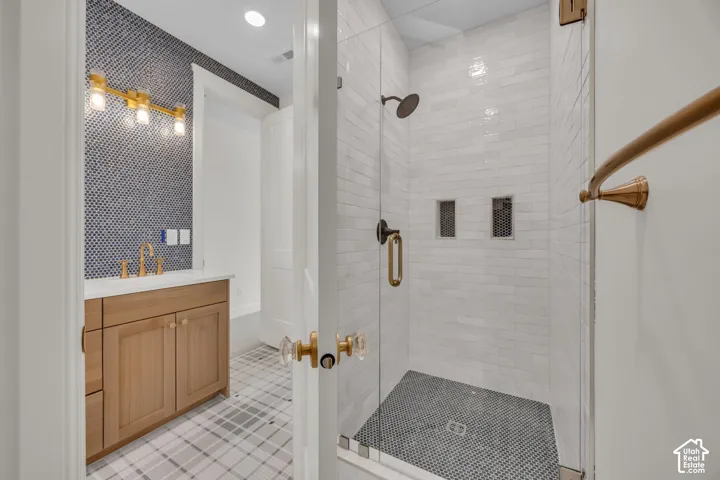 Glass-enclosed shower with subway tile surround and integrated shelving