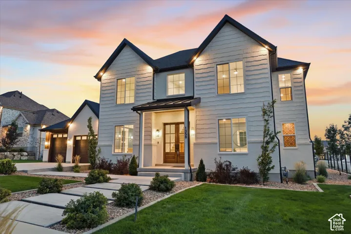 Contemporary two-story residence with a covered entryway, dual-pane windows, and a manicured lawn