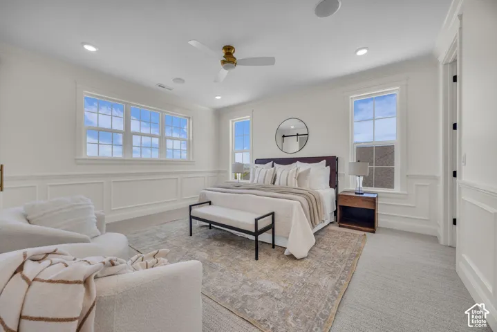 Expansive room featuring multiple windows, recessed lighting, crown molding, and wainscoting
