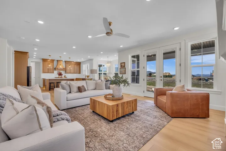 Expansive living area featuring light wood-finish flooring, recessed lighting, and a ceiling fan