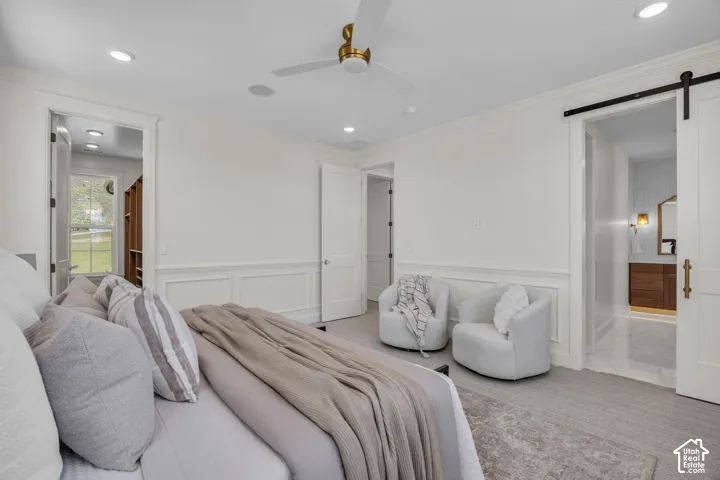 White paneled walls, recessed lighting, and a ceiling fan with a gold-tone fixture