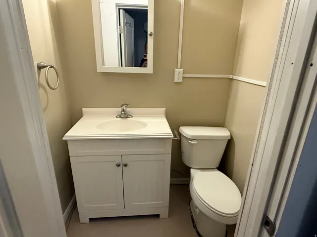 White vanity with integrated sink, chrome faucet, and mirrored medicine cabinet