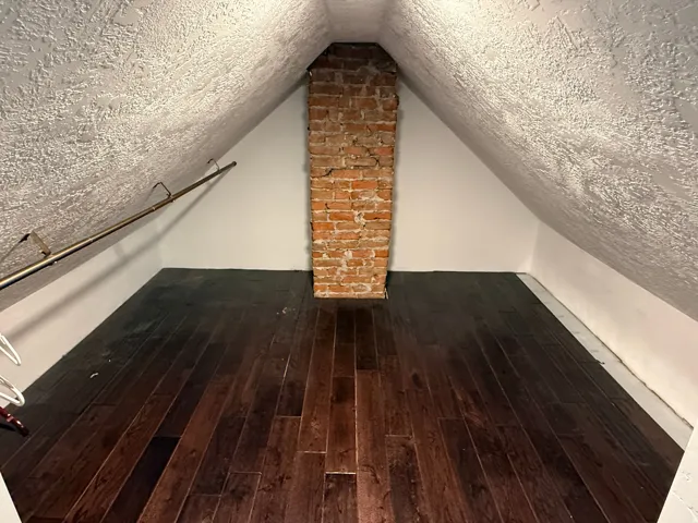 Wood-finish flooring with an exposed brick chimney