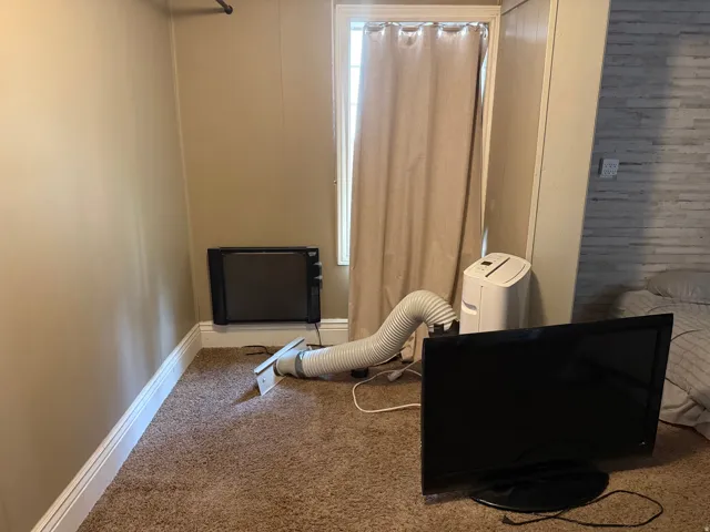 Carpeted flooring, painted walls, and window with curtain
