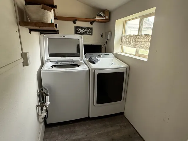 Utility area featuring a window, built-in shelving, and wood-finish flooring