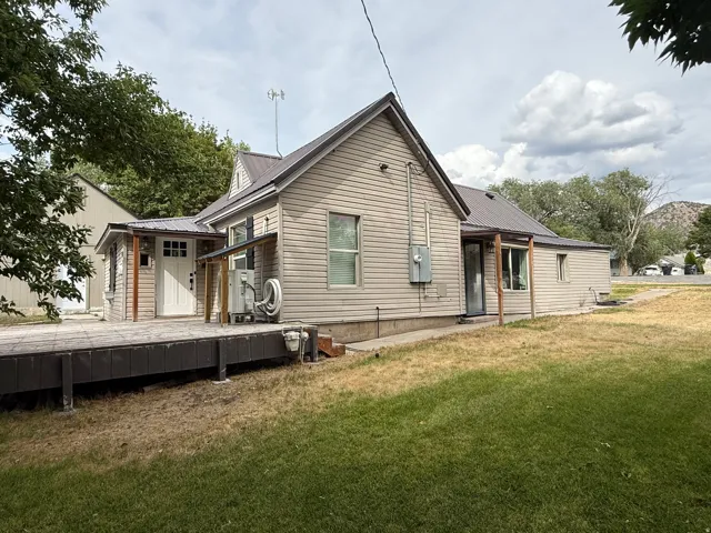 Exterior featuring horizontal siding, a metal roof, an expansive rear deck, and a detached outbuilding