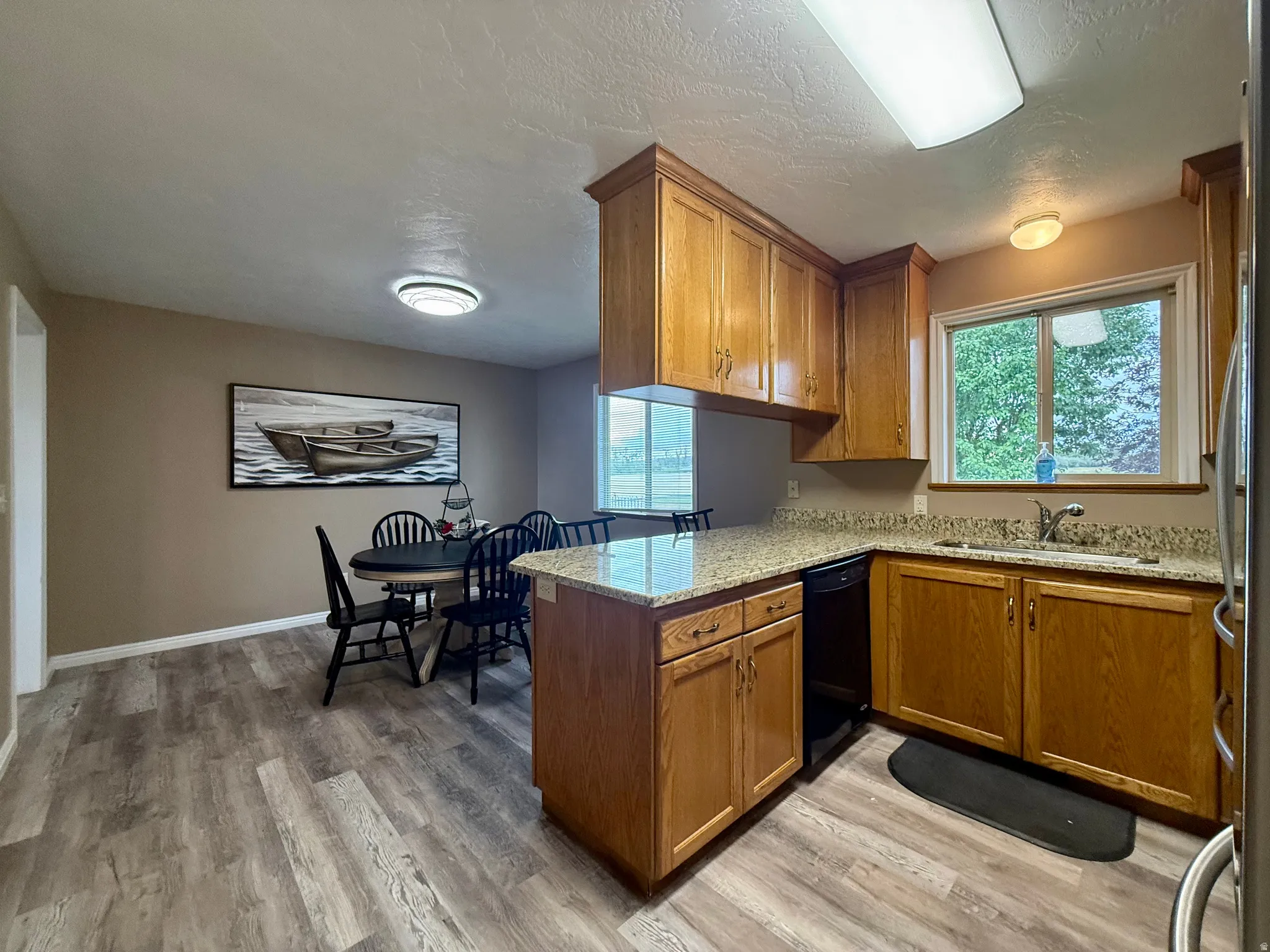 Wood-finish flooring throughout, wood cabinetry, stone countertops, and a built-in dishwasher