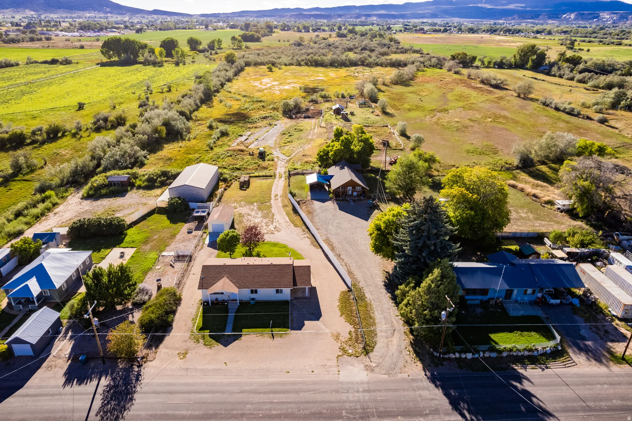Expansive property featuring multiple structures, open land, and mountain scenery