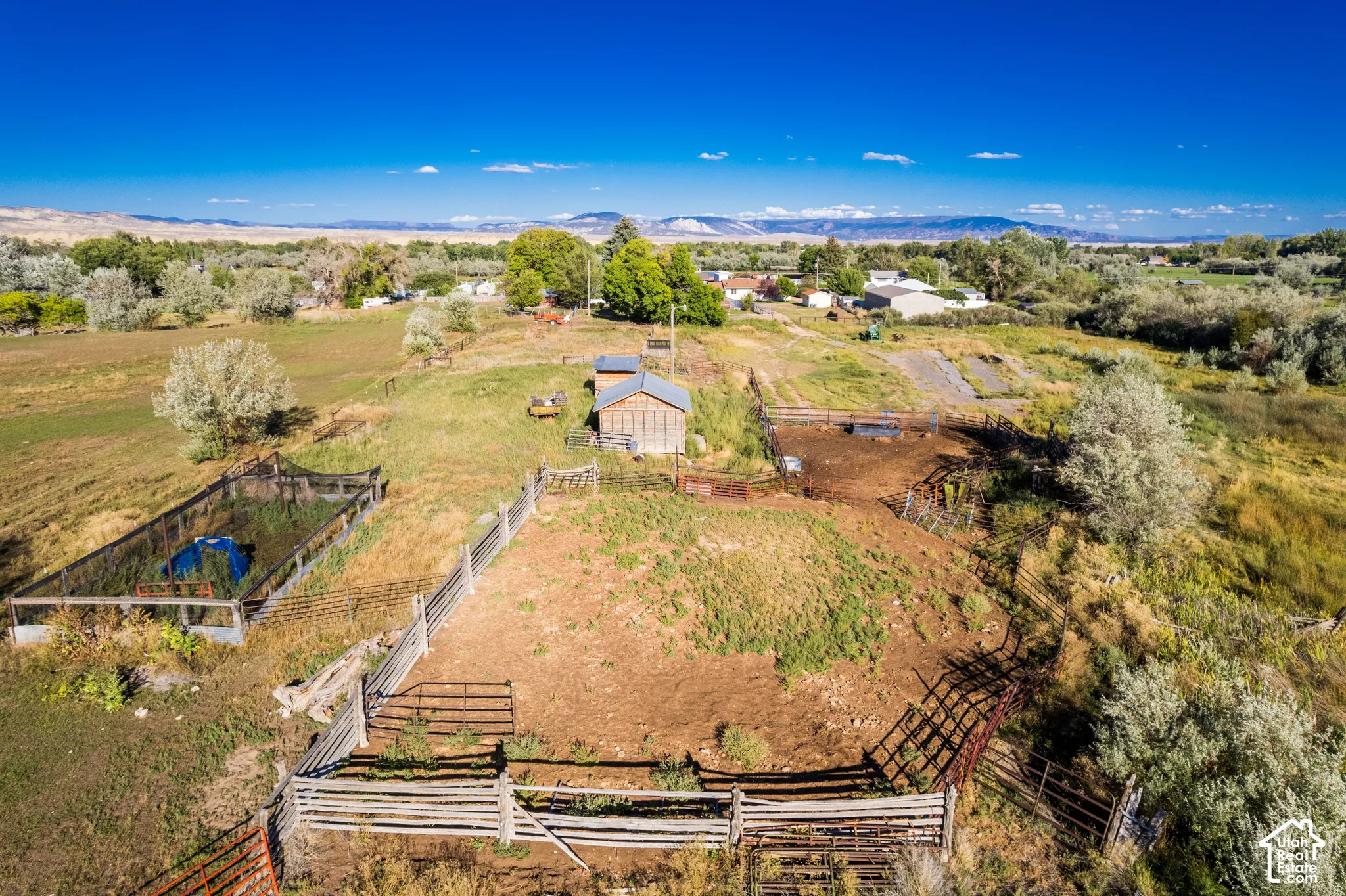 Expansive rural property featuring an agricultural outbuilding, fenced enclosures, and a large fenced recreation area