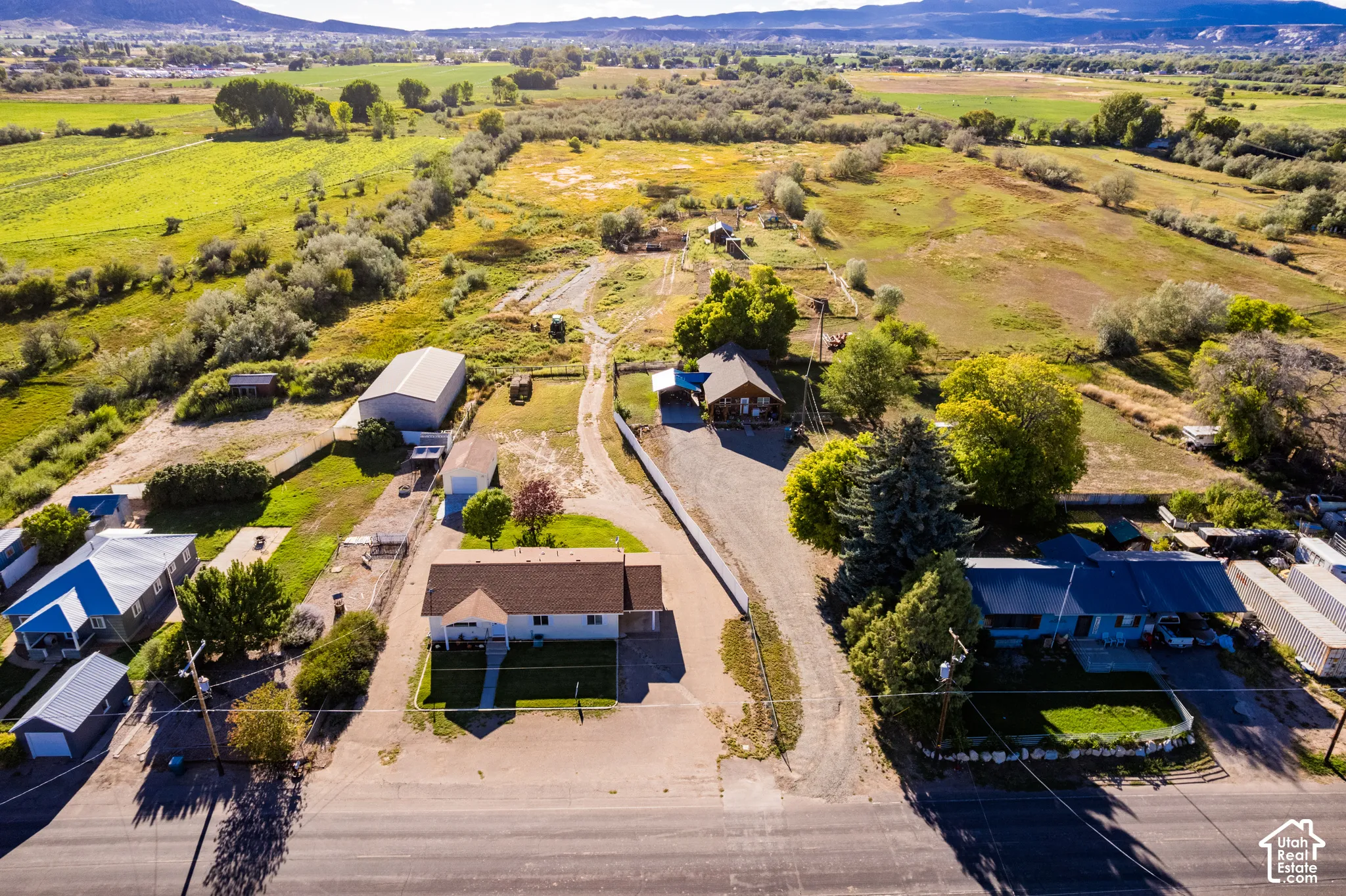 Expansive property featuring multiple structures, open land, and mountain scenery