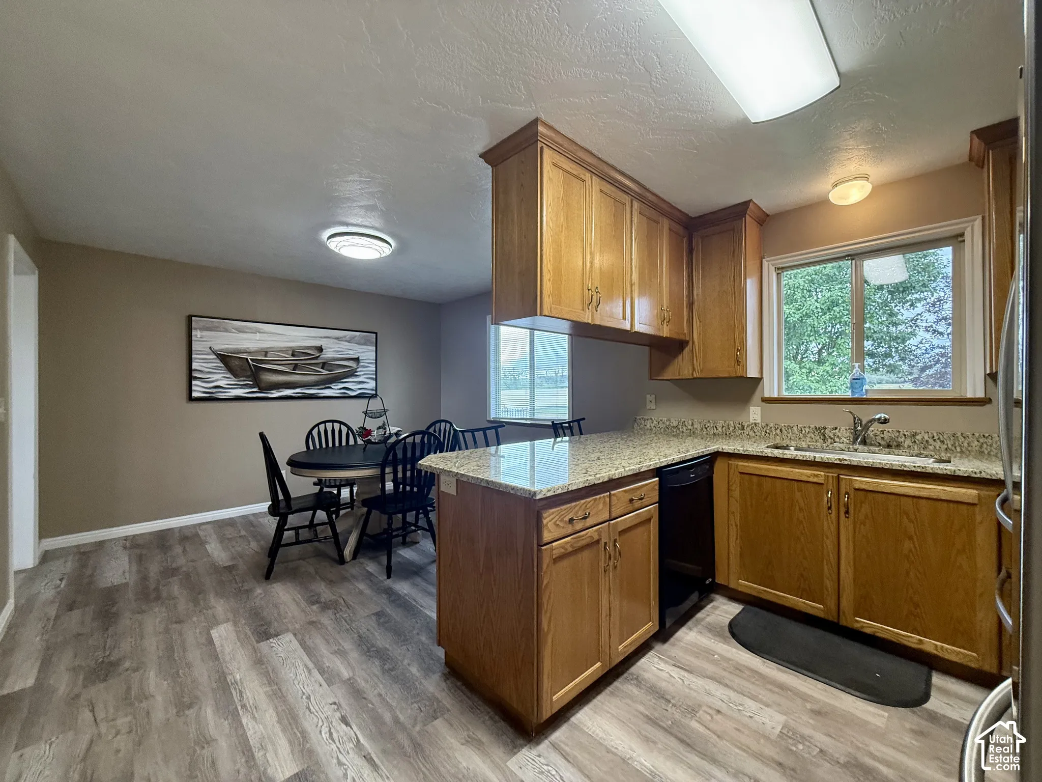 Wood-finish flooring throughout, wood cabinetry, stone countertops, and a built-in dishwasher