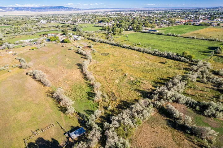 Expansive land parcel featuring varied terrain, mature tree lines, and a distant mountain range