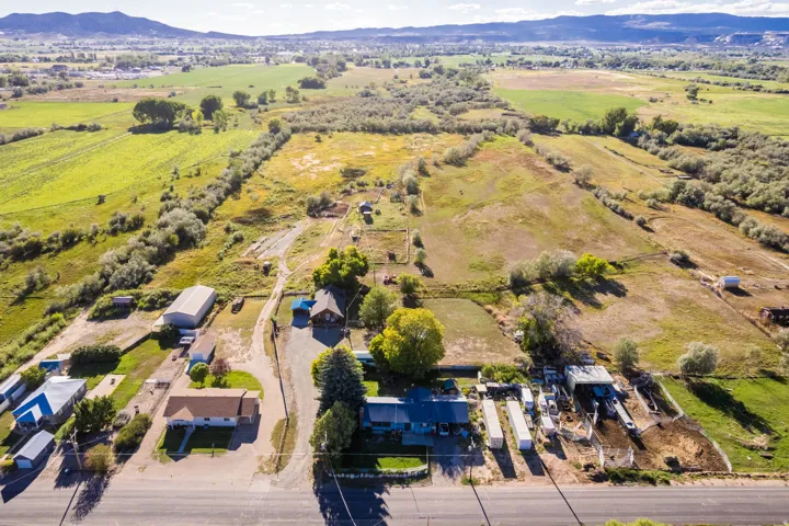 Expansive landscape featuring multiple structures, open fields, and surrounding natural foliage