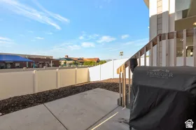 Concrete patio with wood railings and a privacy fence