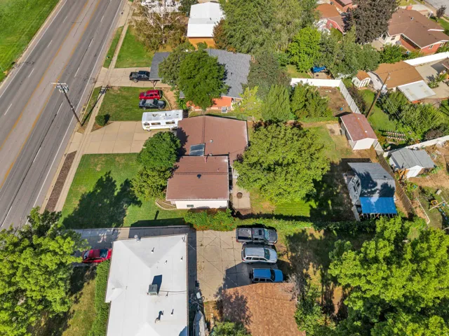 Expansive lot featuring mature trees, a paved driveway, and a detached structure