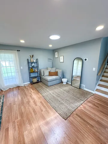 Recessed lighting, wood-finish flooring, a skylight, and a glass-paned door