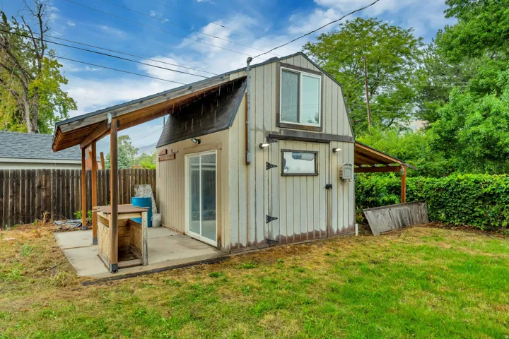 Two-story outbuilding with a gambrel roof and vertical siding