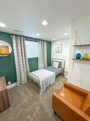 Wall-to-wall carpeting, recessed lighting, and a window with blinds and curtains