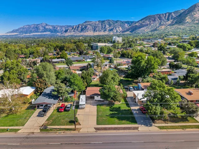 Mountain backdrop and residential setting, featuring mature trees and a paved street