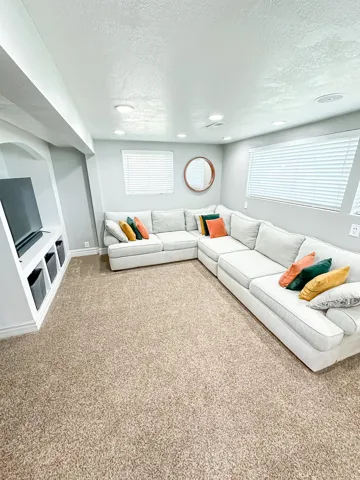Built-in entertainment center, recessed lighting, wall-mounted windows, and light-toned carpeting