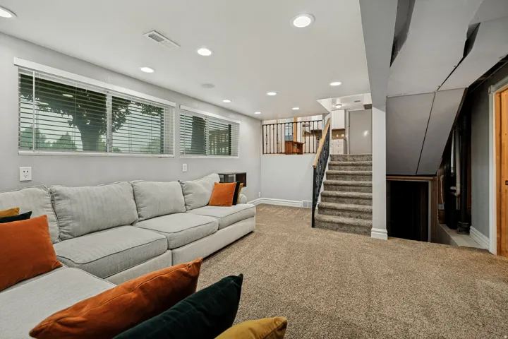 Recessed lighting illuminates the carpeted flooring and light grey walls