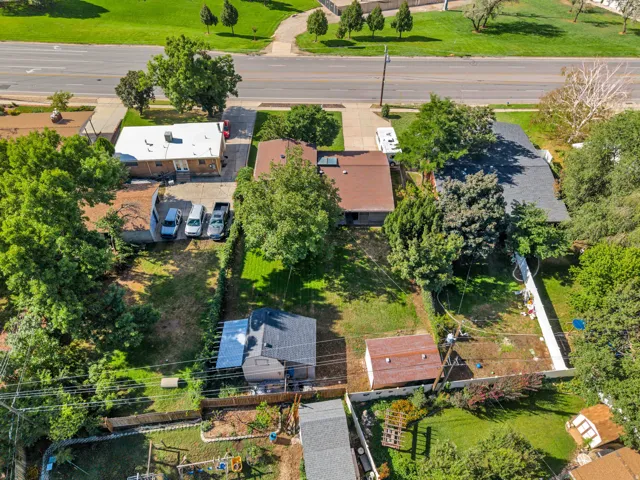 Expansive lot featuring multiple structures, mature trees, and a spacious green lawn