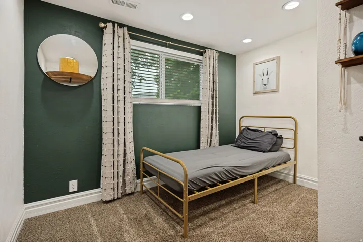 Recessed ceiling lighting, window with blinds, textured wall finishes, and carpet flooring
