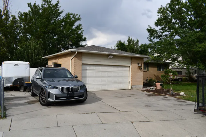 Brick exterior with a shingle roof and a two-car garage