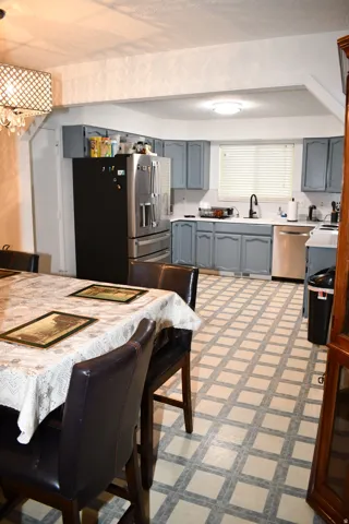 Kitchen featuring gray cabinetry, light countertops, and a stainless steel refrigerator