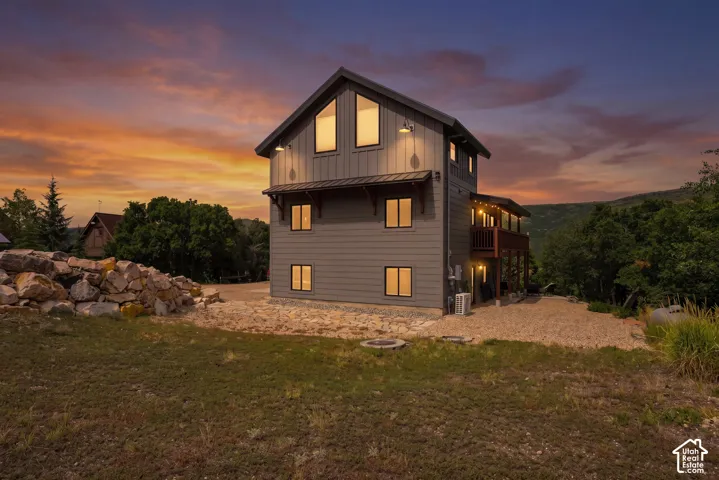 Modern exterior with board and batten siding, multiple windows, and a raised wooden deck