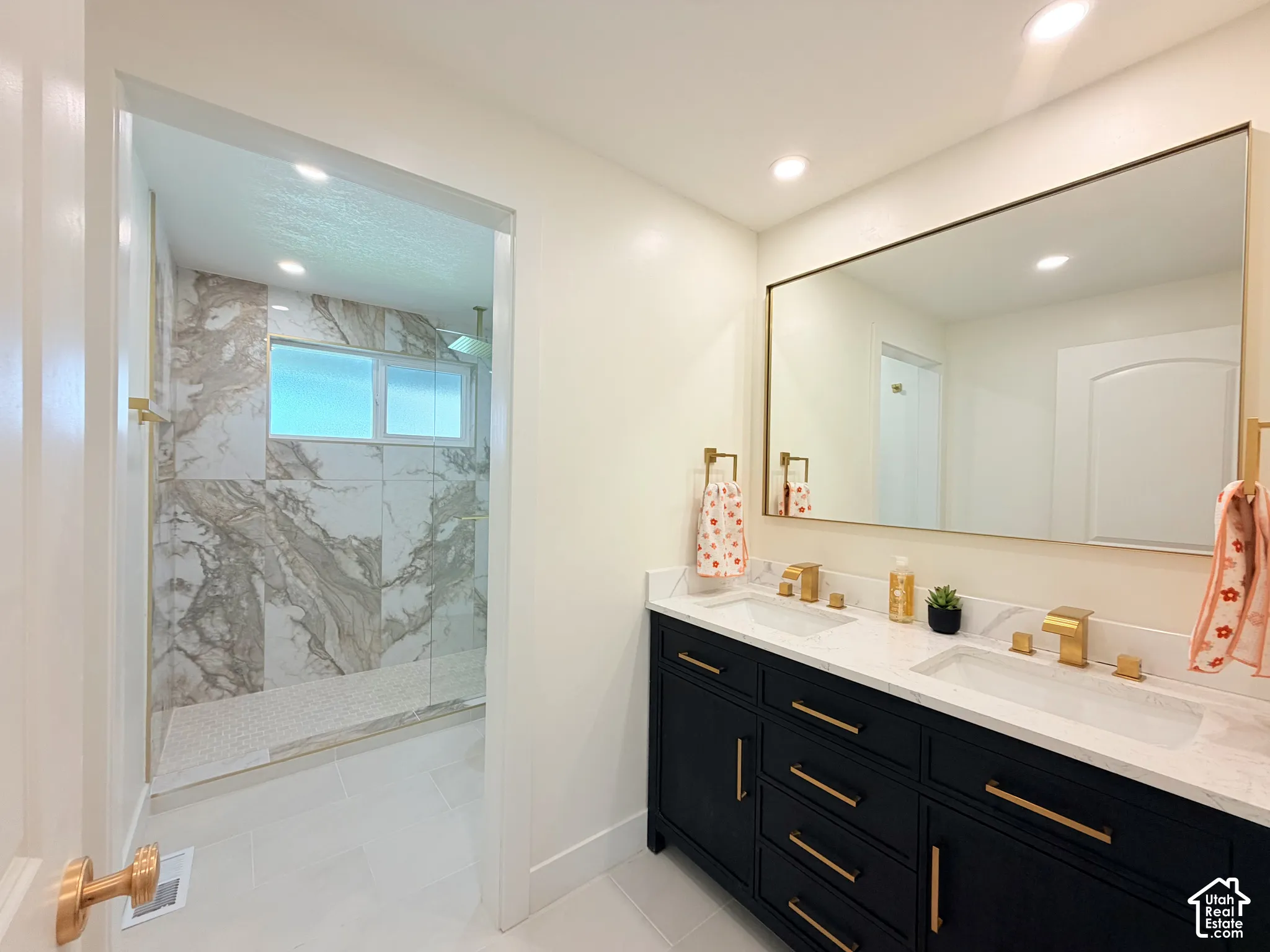 Dual vanity with dark cabinetry, gold-finish hardware, and a white countertop