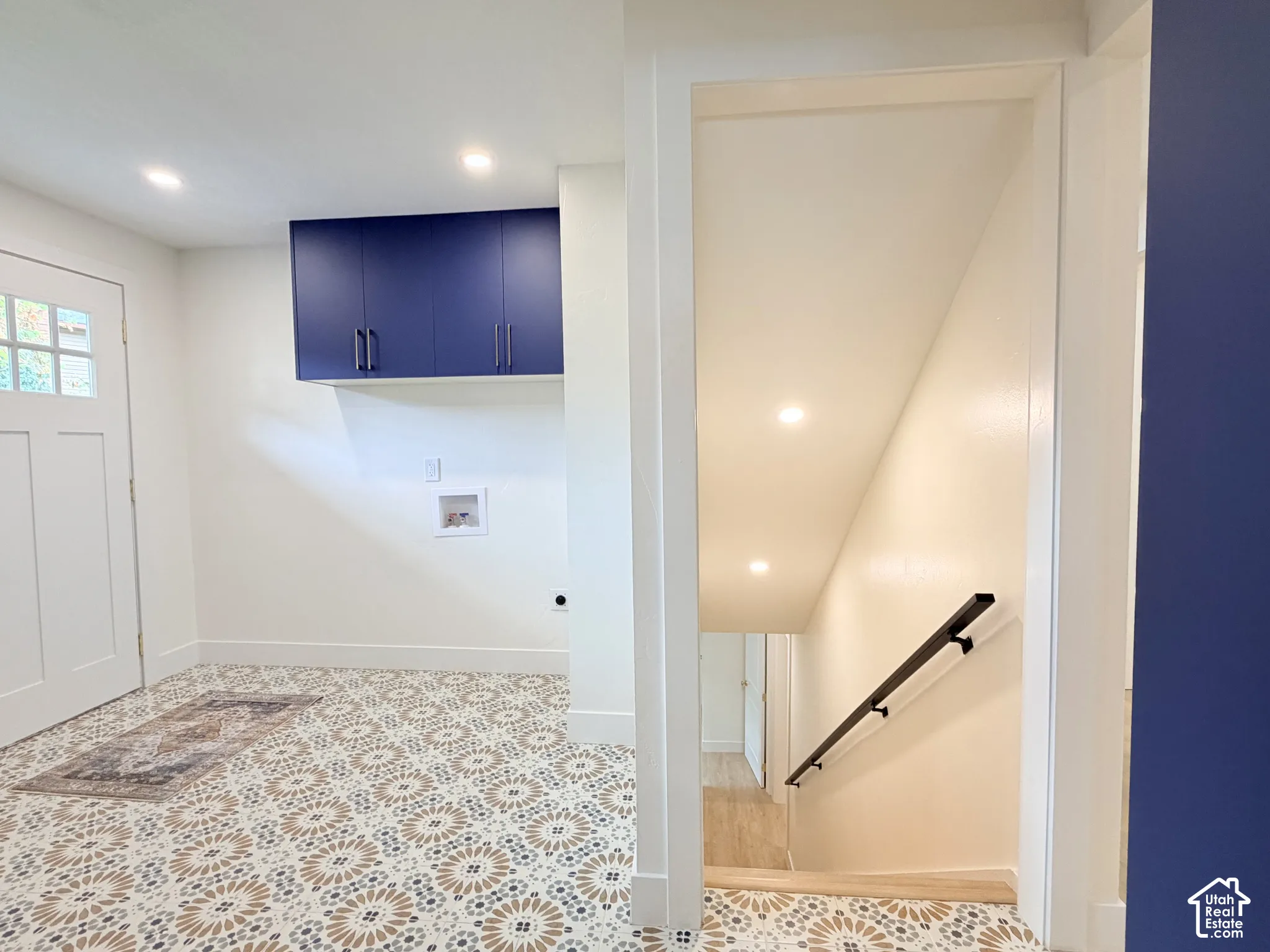Laundry area with patterned flooring, recessed lighting, and built-in blue cabinetry