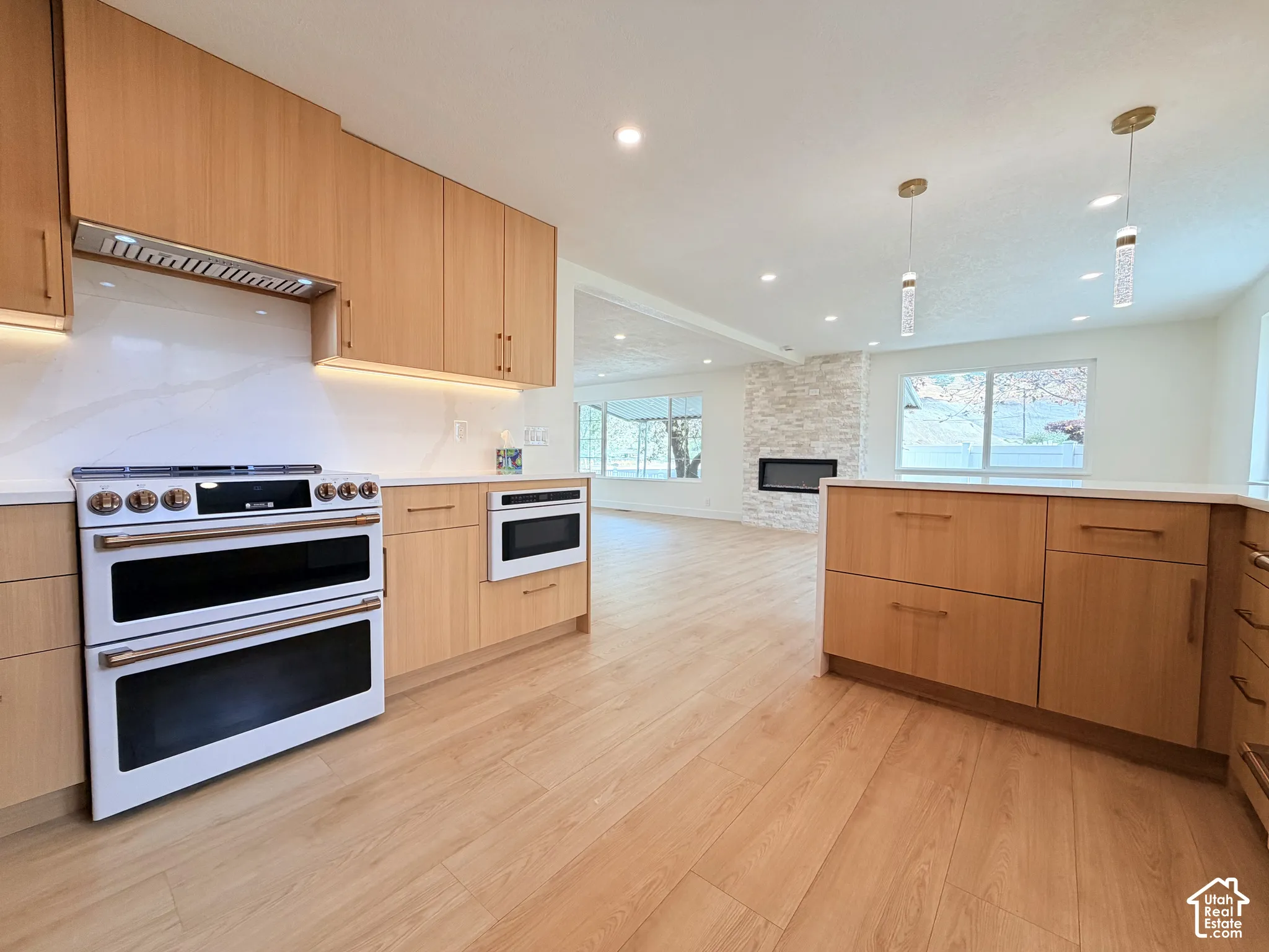 Wood-finish flooring throughout, complemented by light wood cabinetry and white countertops