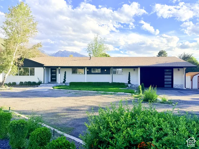Single-story residence featuring a brown shingle roof and a two-tone exterior with white and dark trim