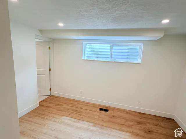 Recessed lighting, wood-finish flooring, and white interior doors