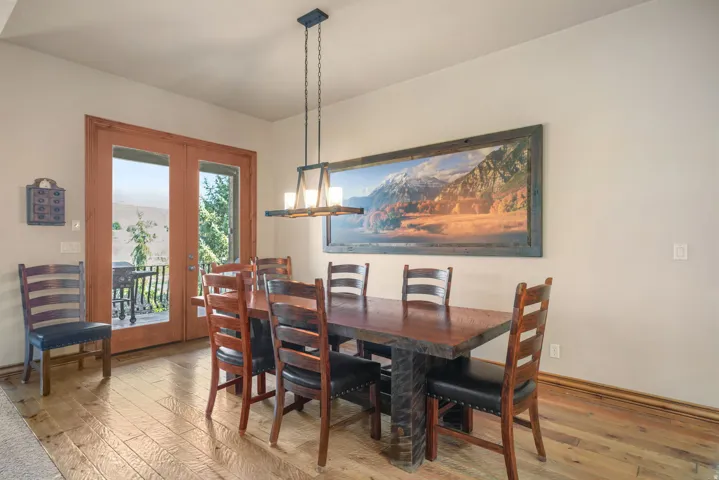 Wood-finish flooring, light tan wall paint, and a modern linear pendant light fixture