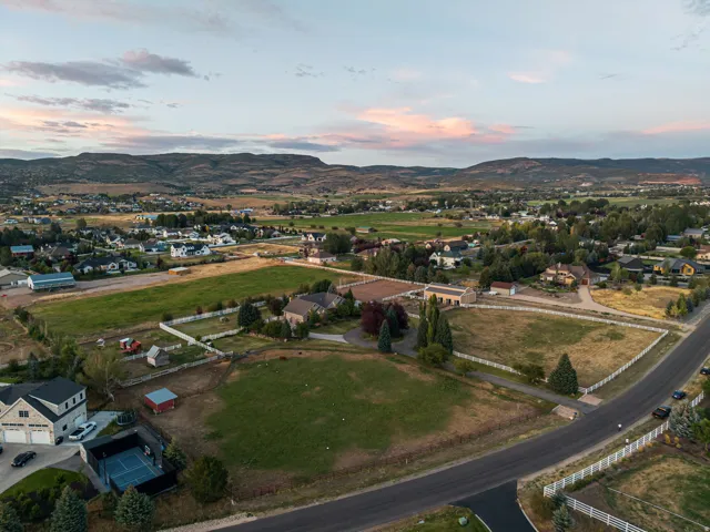 Expansive aerial view showcasing multiple residential properties with mature landscaping, manicured grounds, and established tree coverage