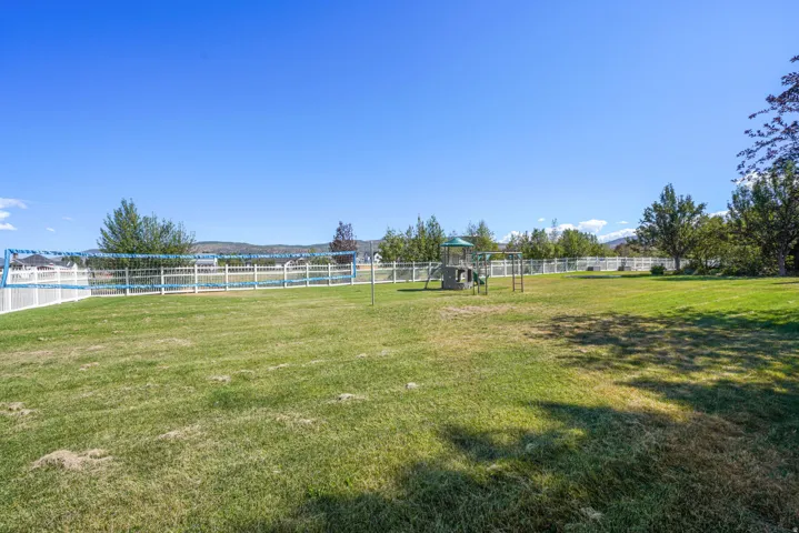 Expansive lawn area with a white picket fence perimeter